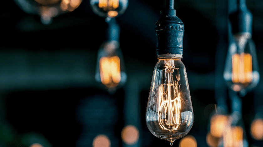 Cool warm lighting hanging from the ceiling against a dark blue background.